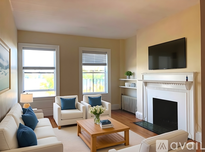 A living room with a fireplace, a couch, a chair, a coffee table, and a television.