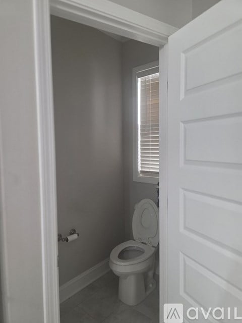 A white toilet in a small bathroom with a white door.