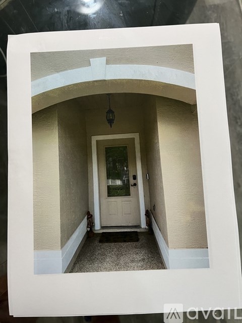 A white door is in a hallway with a light hanging from the ceiling.