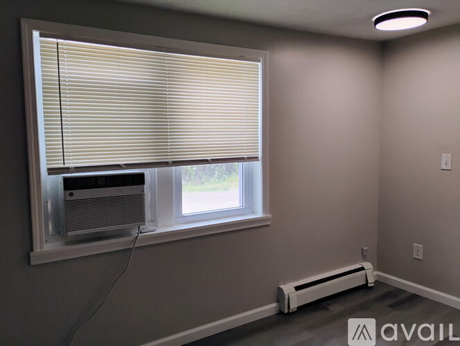 A window with blinds and a window air conditioner unit.