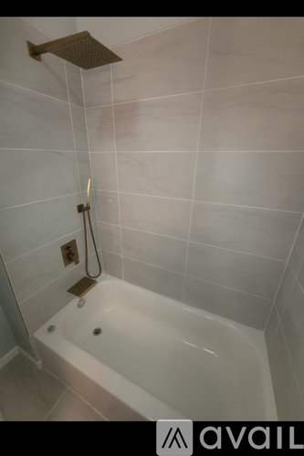 A white bathtub with a shower head above it.