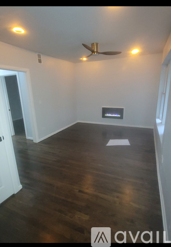A room with wooden flooring and a ceiling fan.