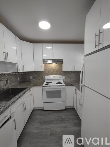 A kitchen with white cabinets and a black stove top oven.