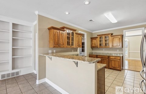 A kitchen with white cabinets and a granite countertop.