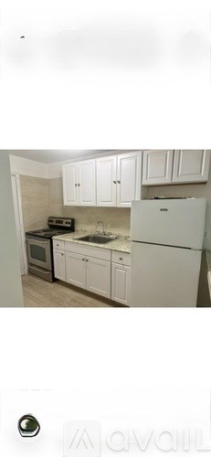 A kitchen with white cabinets and appliances.