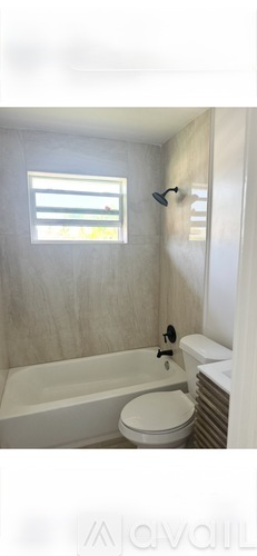 A white bathroom with a toilet, sink, and bathtub.