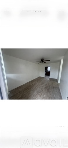 A room with wooden flooring and a ceiling fan.