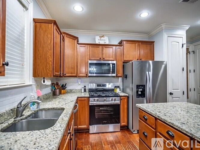 A kitchen with wooden cabinets and granite countertops is available for rent.