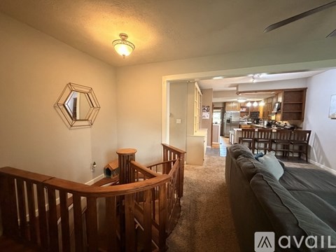 A living room with a couch and a wooden staircase.