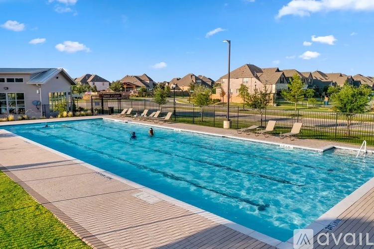 A swimming pool with people in it and a building in the background.