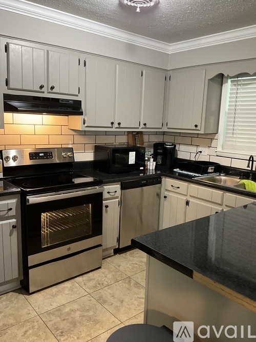 A kitchen with black countertops and white cabinets.