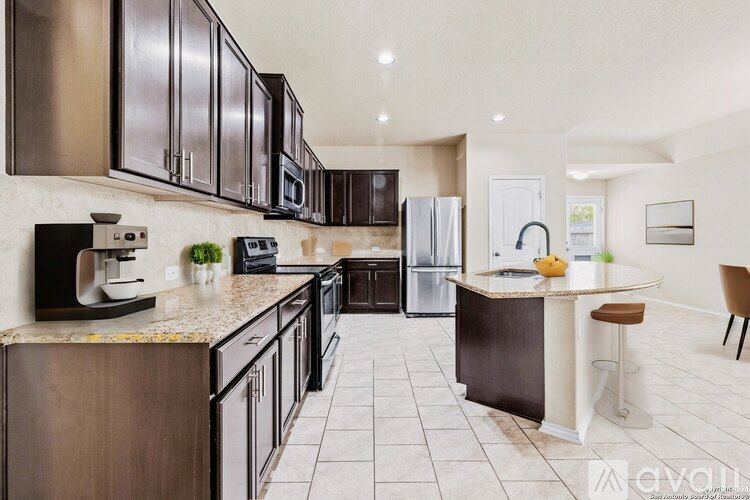 A kitchen with dark brown cabinets and a white island.