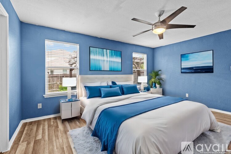 A bedroom with two beds and a ceiling fan.