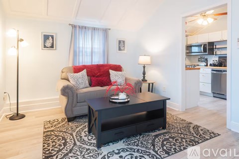 A living room with a grey couch and a black coffee table.