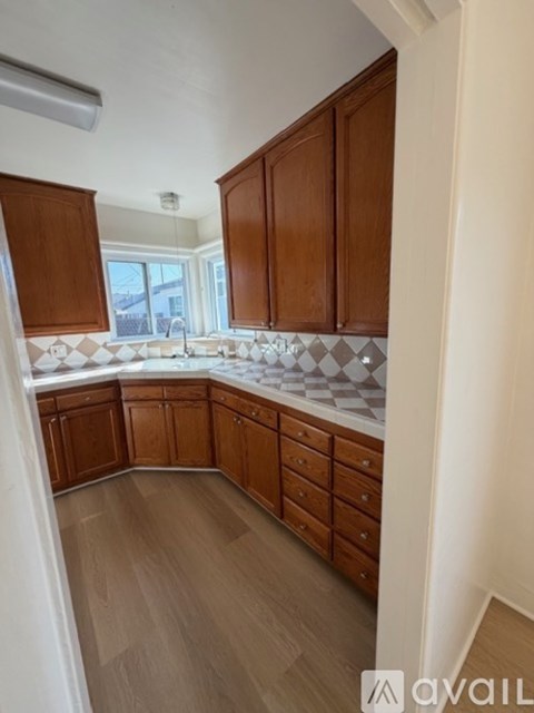 A kitchen with wooden cabinets and a checkered backsplash.