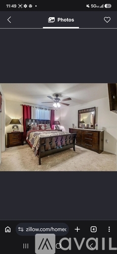 A bedroom with a bed, dresser, and ceiling fan.
