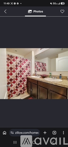 A bathroom with a shower curtain and a sink.