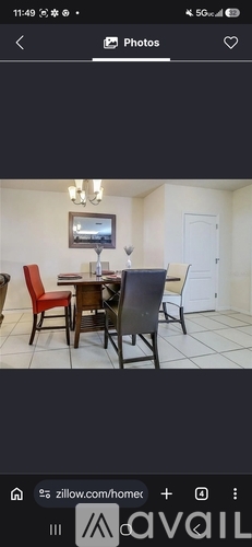 A dining room with a table and chairs.