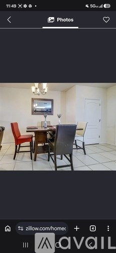 A dining room with a table and chairs.