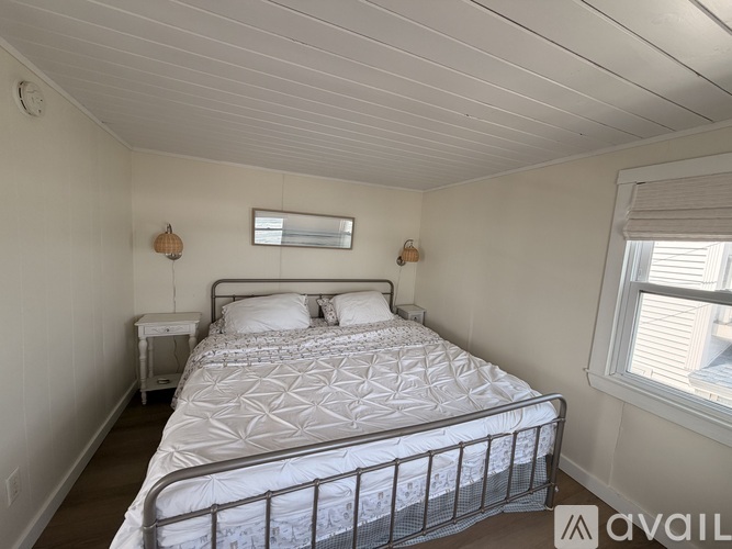 A bedroom with a large bed and a window.