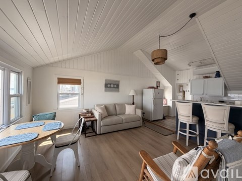 A well-lit, spacious living room with a dining table and chairs.