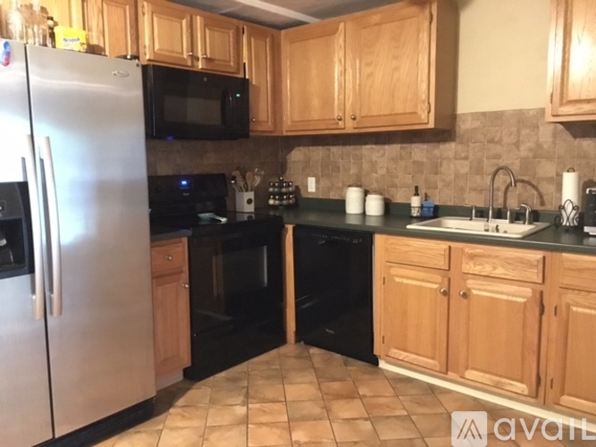 A kitchen with wooden cabinets and black appliances.