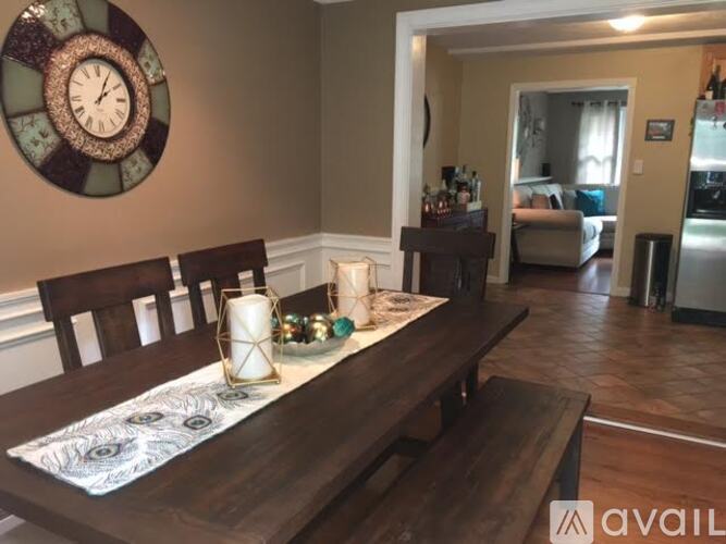 A dining room with a wooden table and chairs.