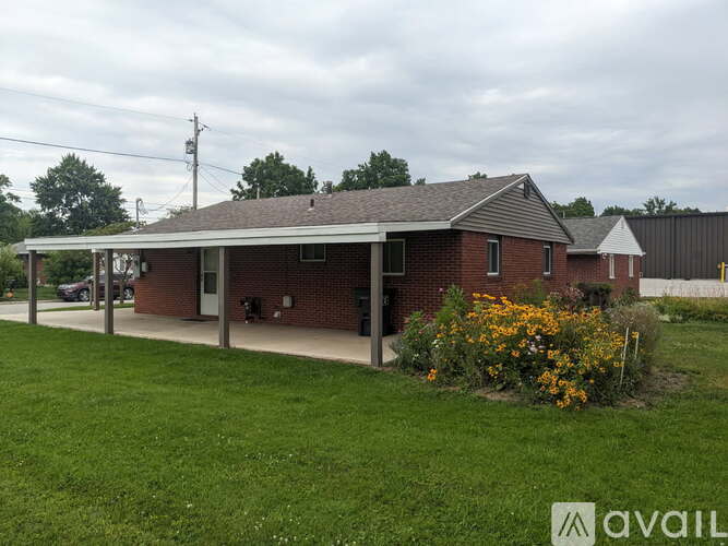 A house with a covered porch and a green lawn in front.
