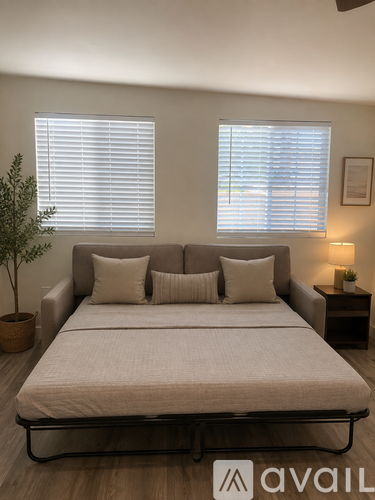 A bedroom with a large bed and a plant in a pot.