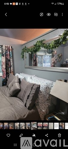 A bedroom with a bed and a window with a view of a tree.