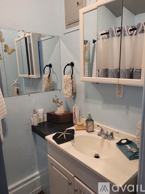 A bathroom with a sink, mirror, and towel rack.