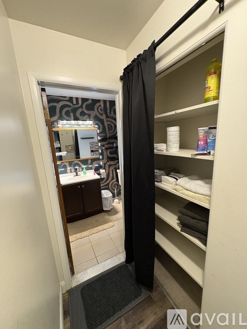 A bathroom with a mirror and a shelf with toiletries.