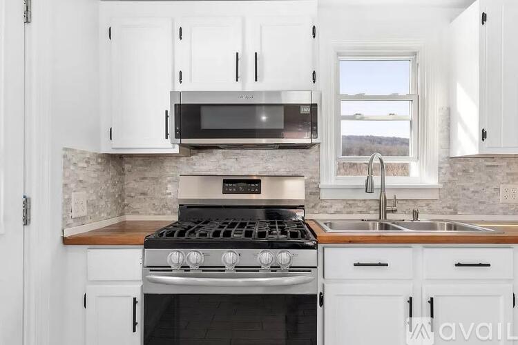 A kitchen with a stove, microwave, and cabinets.
