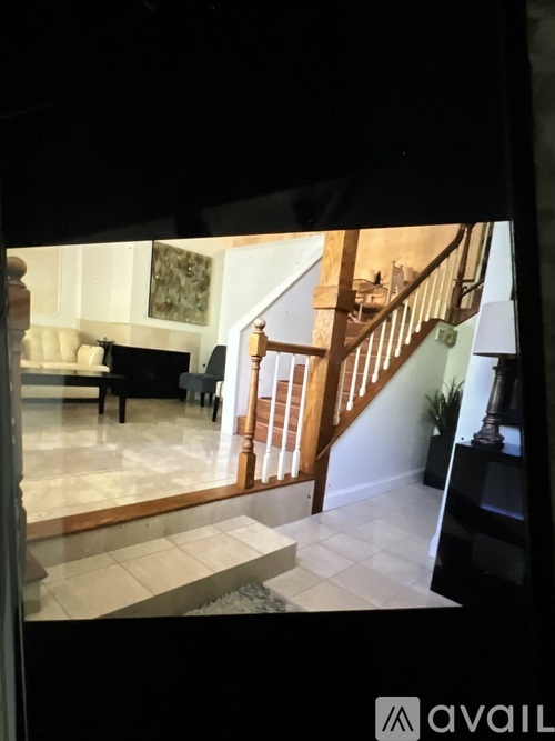 A living room with a piano and a staircase.