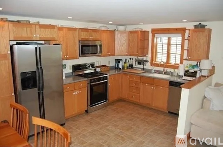 A kitchen with wooden cabinets and a refrigerator.