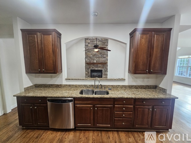 A kitchen with wooden cabinets and a granite countertop.
