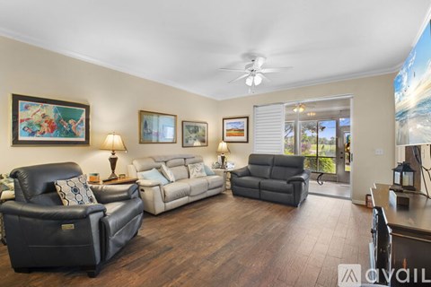 A living room with a black leather chair and a white couch.