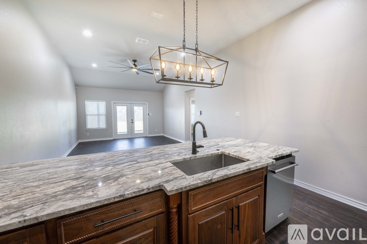 A kitchen with a marble countertop and wooden cabinets.