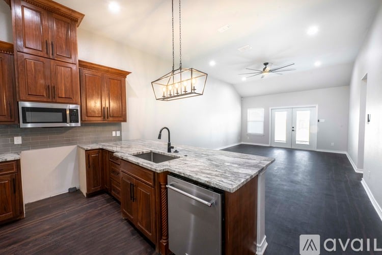 A kitchen with wooden cabinets and a marble countertop is available for rent.