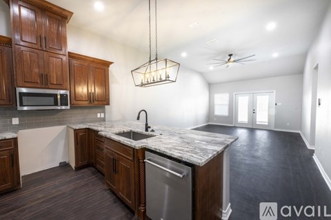 A kitchen with wooden cabinets and a marble countertop is available for rent.