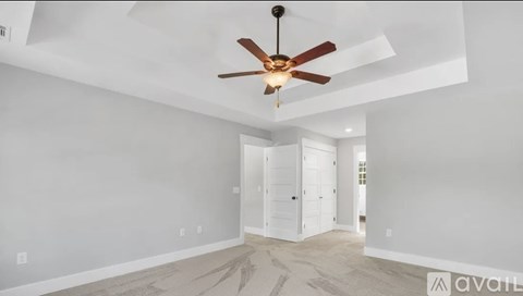 A room with a ceiling fan and a carpeted floor.
