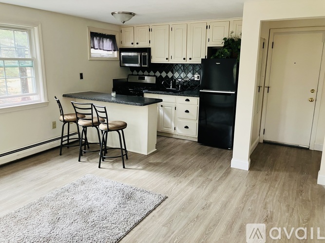 A kitchen with black appliances and white cabinets.