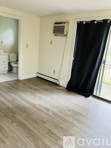 A room with a black curtain and a wooden floor.