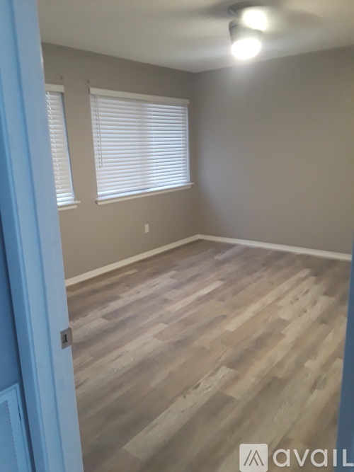 A room with wooden flooring and a ceiling fan.