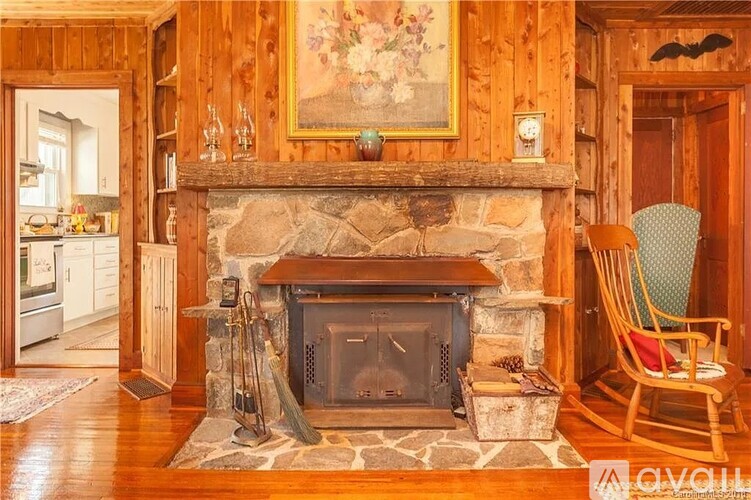 A cozy living room with a fireplace and a painting above it.