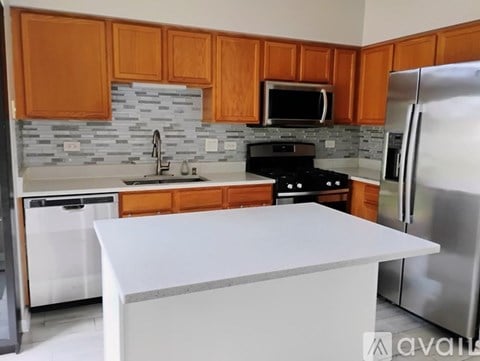A kitchen with wooden cabinets and a white island.