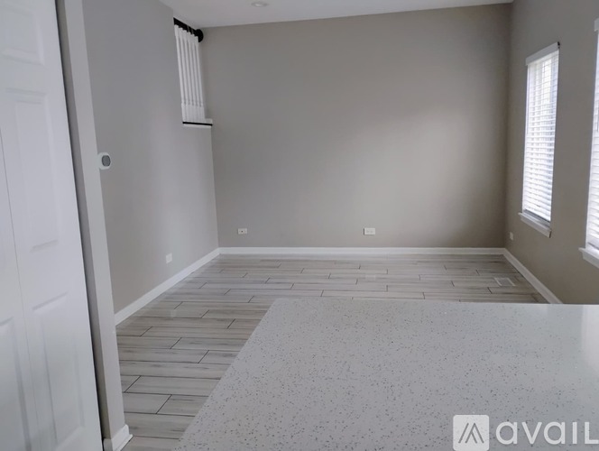 A room with a tiled floor and a window with blinds.