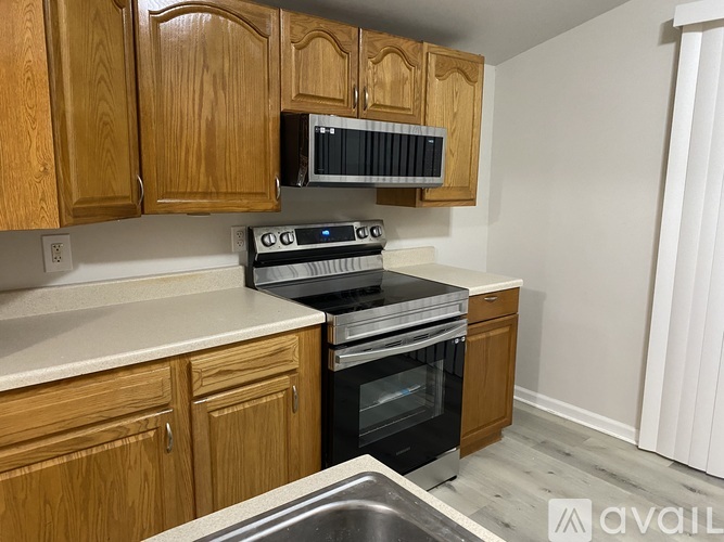 A kitchen with wooden cabinets and a black oven.
