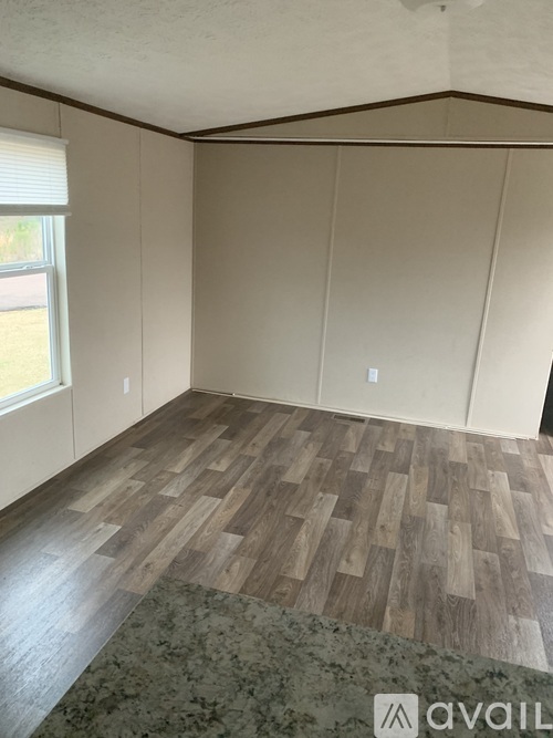 A room with wooden flooring and a window.