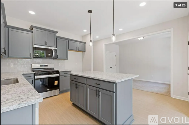A kitchen with grey cabinets and a granite countertop.